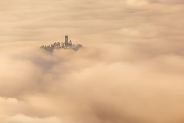 Castel Baradello tower rise up from a sea of clouds at sunrise, Como, Lombardy, Italy, Europe