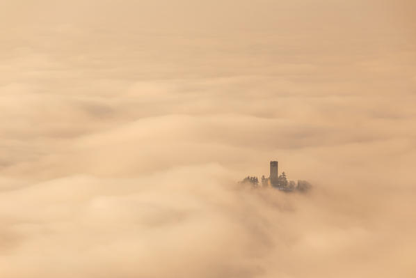 Castel Baradello tower rise up from a sea of clouds at sunrise, Como, Lombardy, Italy, Europe