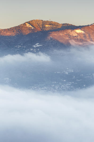 Bisbino mount rise up from a sea of clouds at sunrise, Como province, Lombardy, Italy, Europe
