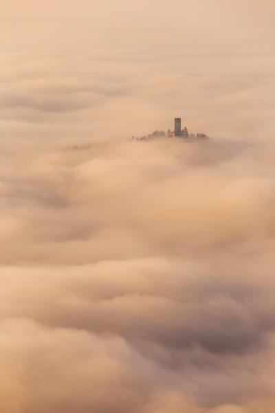 Castel Baradello tower rise up from a sea of clouds at sunrise, Como, Lombardy, Italy, Europe