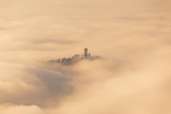 Castel Baradello tower rise up from a sea of clouds at sunrise, Como, Lombardy, Italy, Europe