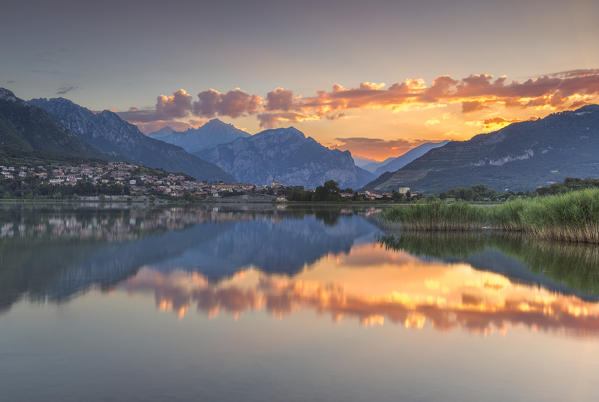 Red clouds and Lecco mountains reflected on  lake Annone, Lecco province, Brianza, Lombardy, Italy, Europe