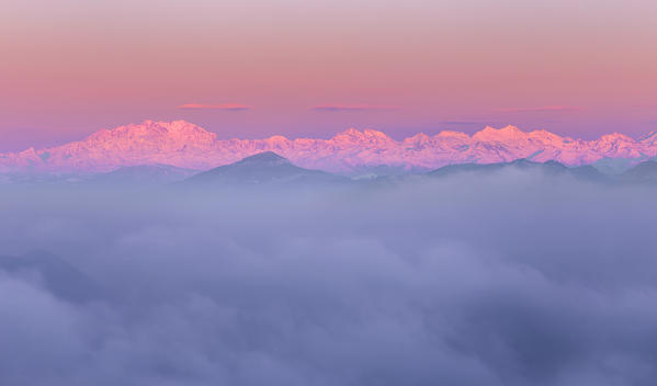 Rosa Mount and other peaks from alps rise up from a sea of clouds at sunrise. View from Brunate town (Como province, Lombardy, Italy, Europe)