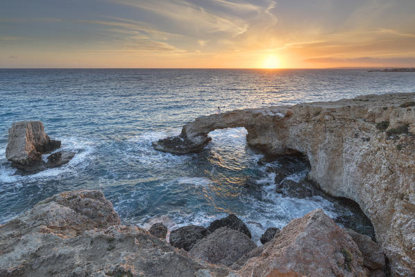 Cyprus, Ayia Napa, Cape Greco, woman whit a white dress at sunset standing over the Love Bridge 