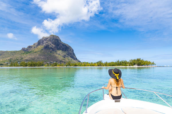 A young woman is relaxing on a boat in Le Morne bay. Le Morne Brabant Peninsula, Black River (Riviere Noire), Mauritius, Africa (MR)