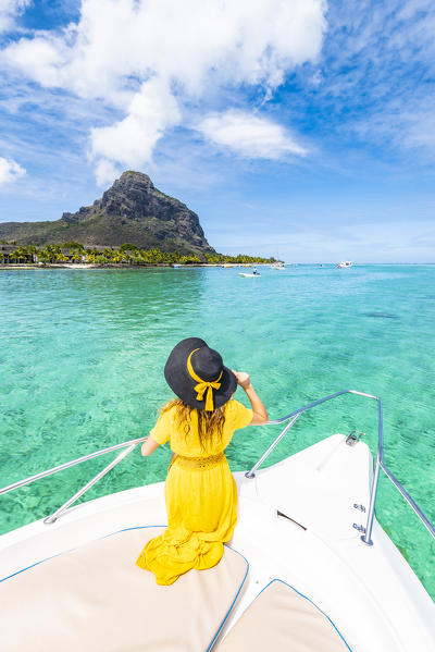 A young woman is relaxing on a boat in Le Morne bay. Le Morne Brabant Peninsula, Black River (Riviere Noire), Mauritius, Africa