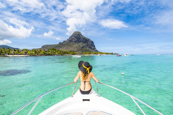 A young woman is relaxing on a boat in Le Morne bay. Le Morne Brabant Peninsula, Black River (Riviere Noire), Mauritius, Africa