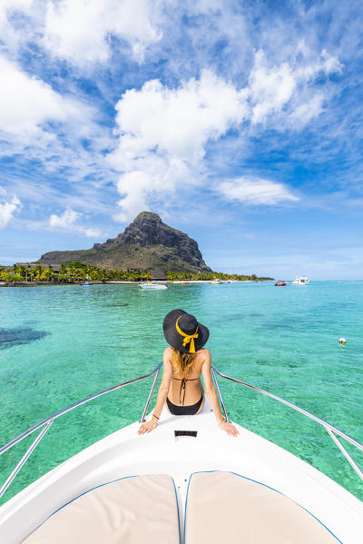 A young woman is relaxing on a boat in Le Morne bay. Le Morne Brabant Peninsula, Black River (Riviere Noire), Mauritius, Africa (MR)