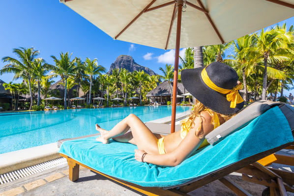 A young woman relaxing in the swimming pool of the Beachcomber Paradis Hotel, Le Morne Brabant Peninsula, Black River (Riviere Noire), Mauritius (MR) (PR)