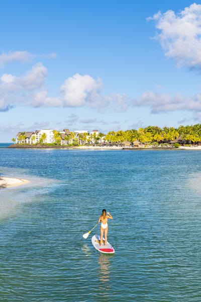A young woman doing stand up paddle in the bay of the Shangri-La Le Toussrok hotel, Trou d'Eau Douce, Flacq district, Mauritius, Africa (MR)