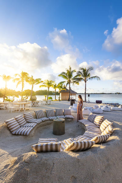 A tourist enjoying the sunset at the beach bar of the Shangri-La Le Toussrok hotel, Trou d'Eau Douce, Flacq district, Mauritius, Africa (MR)