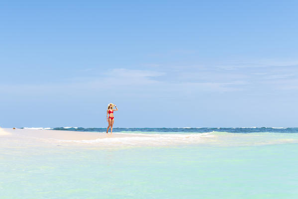 Zapatilla island, Bocas del Toro province, Panama, Central America. A young woman enjoys the sun