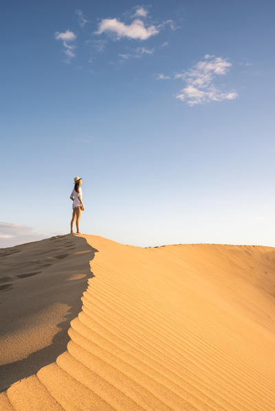 Tourist admiring the view on sand dunes. Maspalomas, Las Palmas, Gran Canaria, Canary Islands, Spain, Europe