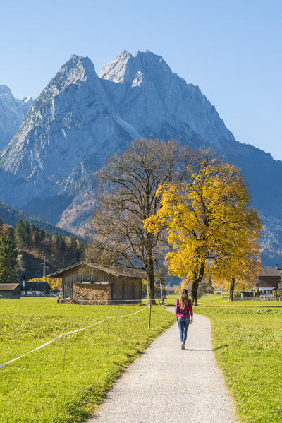 Garmisch Partenkirchen, Bavaria, Germany, Europe. A young woman walking on a footpath in autumn