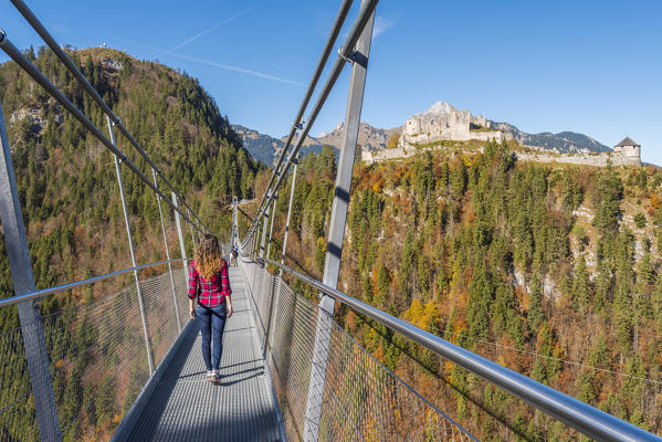 Reutte, Tyrol, Austria, Europe. Ehrenberg Castle and the Highline 179, the world’s longest pedestrian suspension bridge. A young woman cross the bridge