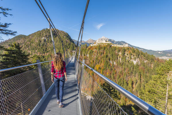 Reutte, Tyrol, Austria, Europe. Ehrenberg Castle and the Highline 179, the world’s longest pedestrian suspension bridge. A young woman cross the bridge