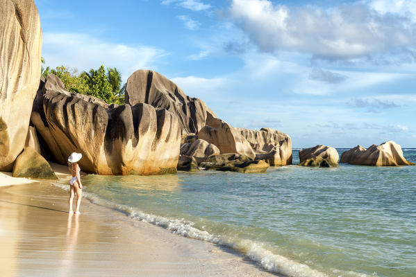 Beautiful young woman admiring the view on Anse Source d'Argent beach. La Digue island, Seychelles, Africa (MR)