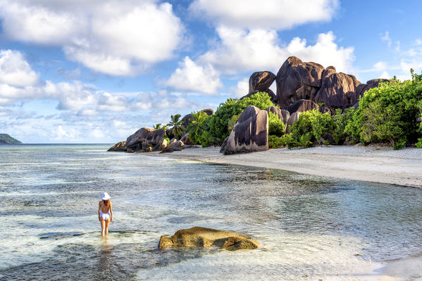 Beautiful young woman strolling along Anse Source d'Argent beach. La Digue island, Seychelles, Africa  