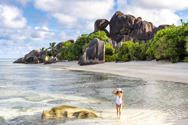 Beautiful young woman strolling along Anse Source d'Argent beach. La Digue island, Seychelles, Africa  (MR)