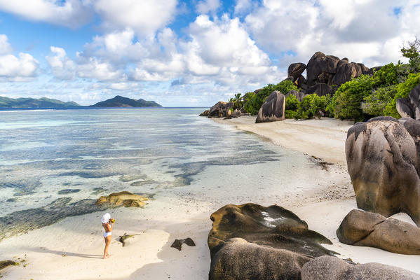 Beautiful young woman relaxing on Anse Source d'Argent beach. La Digue island, Seychelles, Africa  