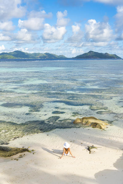 Beautiful young woman relaxing on Anse Source d'Argent beach. La Digue island, Seychelles, Africa  
