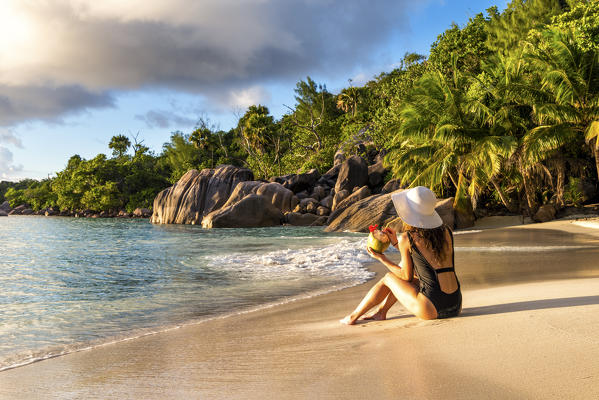 A beautiful woman relaxing on the beach. Anse Lazio, Praslin, Seychelles, Africa (MR)