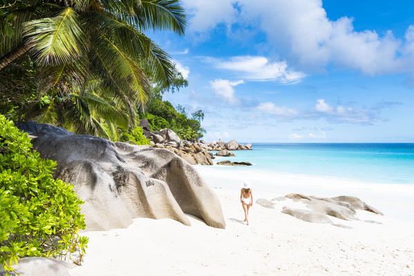 Beautiful woman strolling along Anse Georgette beach. Praslin island, Seychelles, Africa