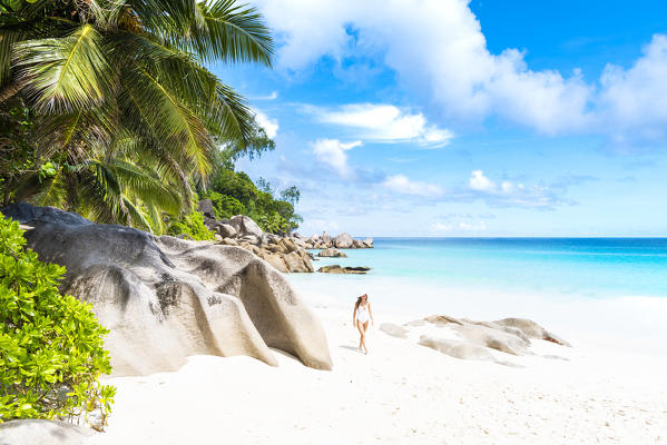 Beautiful woman strolling along Anse Georgette beach. Praslin island, Seychelles, Africa