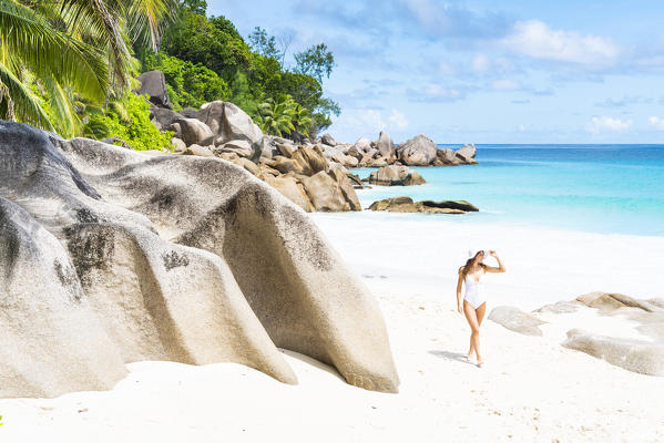Beautiful woman strolling along Anse Georgette beach. Praslin island, Seychelles, Africa