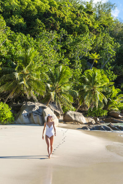 Beautiful woman strolling along Anse Georgette beach. Praslin island, Seychelles, Africa (MR)