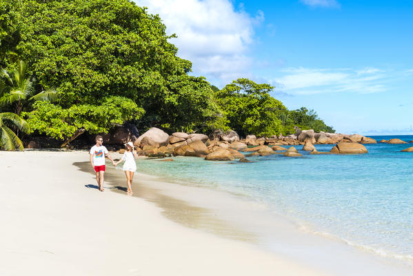 A young couple walking along Anse Lazio beach, Praslin island, Seychelles, Africa