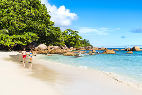 A young couple walking along Anse Lazio beach, Praslin island, Seychelles, Africa (MR)