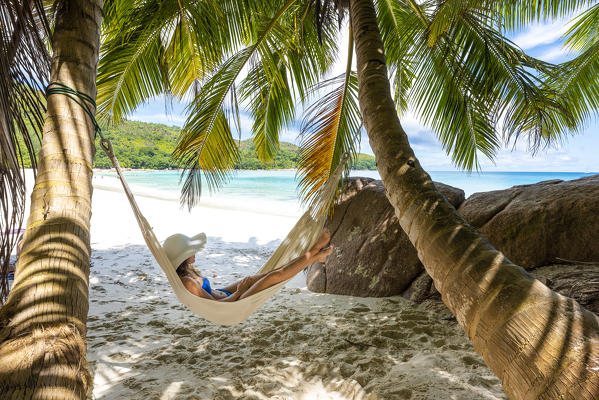 A young woman relaxing on a hammock. Anse Lazio beach, Praslin island, Seychelles, Africa