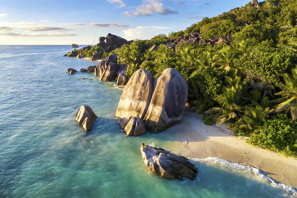 Aerial view of Anse Source d'Argent beach at sunset. A woman enjoys the view. La Digue island, Seychelles, Africa