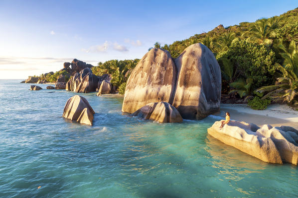 Aerial view of Anse Source d'Argent beach at sunset. A woman enjoys the view. La Digue island, Seychelles, Africa (MR)