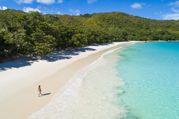 A beautiful woman strolling along Anse Lazio beach, Praslin island, Seychelles, Africa