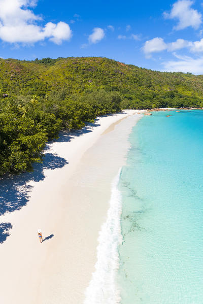 A beautiful woman strolling along Anse Lazio beach, Praslin island, Seychelles, Africa