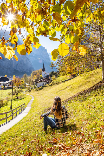 A young woman admires Lauterbrunnen village. Lauterbrunnen, Canton of Bern, Switzerland, Europe (MR)