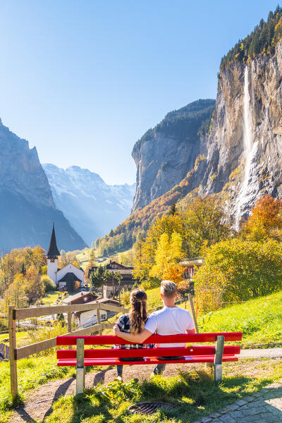 A young couple admires Lauterbrunnen village. Lauterbrunnen, Canton of Bern, Switzerland, Europe