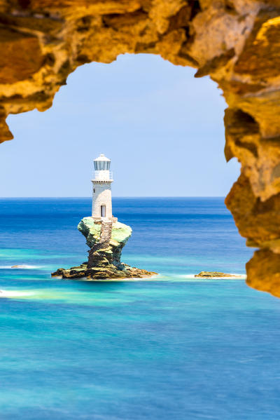 Tourlitis lighthouse framed in a rock window, Andros, Cyclades Archipelago, Greece, Europe