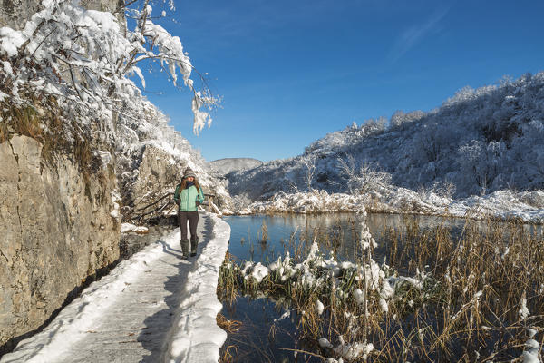 Woman on a wooden walkway of Plitvice Lakes National Park, Plitvicka Jezera, Lika and  Senj County, Croatia