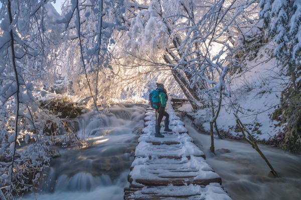 Woman on a wooden walkway of Plitvice Lakes National Park in winter, Plitvicka Jezera, Lika and  Senj County, Croatia