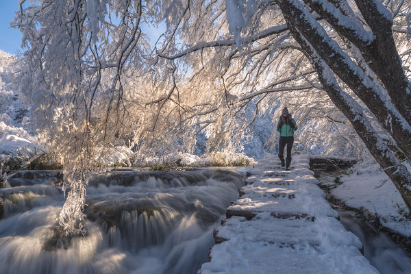 Woman on a wooden walkway of Plitvice Lakes National Park in winter, Plitvicka Jezera, Lika and  Senj County, Croatia
