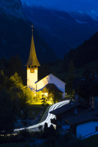 Car lights in the dark near the church of the village of Lauterbrunnen,Interlaken-Oberhasli administrative district, canton of Bern,Bernese Oberland, Switzerland.