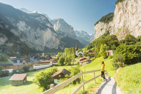 A young woman admiring the village of Lauterbrunnen,Interlaken-Oberhasli administrative district, canton of Bern,Bernese Oberland, Switzerland.