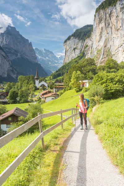 Young woman walking on a street and admiring the village of Lauterbrunnen,Interlaken-Oberhasli administrative district, canton of Bern,Bernese Oberland, Switzerland.