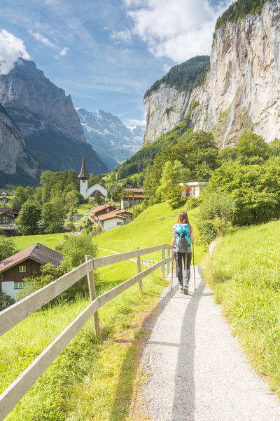 A woman walking on a street in the village of Lauterbrunnen,Interlaken-Oberhasli administrative district, canton of Bern,Bernese Oberland, Switzerland.
