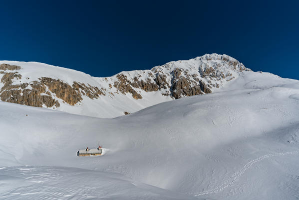 Rifugio Garibaldi in the snow with Gran Sasso in background, Campo Imperatore, Teramo province, Abruzzo, Italy, Europe