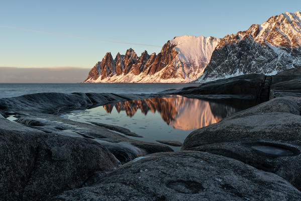 the Devil's teeth Mountain, reflections at sunset in a puddle along the Ersfjorden, Senja, Northern Norway, Europe.