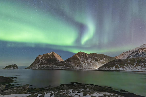 the Northern Lights draw their magic in the sky, illuminating Haukland bay, municipality of Leknes, Vestvagoy, Nordland, Lofoten islands, Norway, Scandinavia, Europe